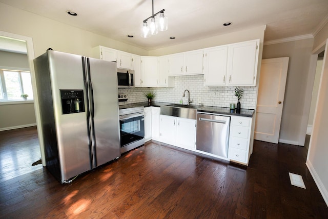 1840 N Columbus St, Lancaster, OH 43130 - kitchen with stainless steel appliances, dark countertops, tasteful backsplash, white cabinetry, and ornamental molding