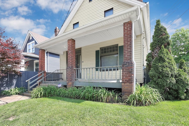 649 E 11th Ave, Columbus, OH 43211 - view of front of house featuring a porch, a front yard, and brick siding
