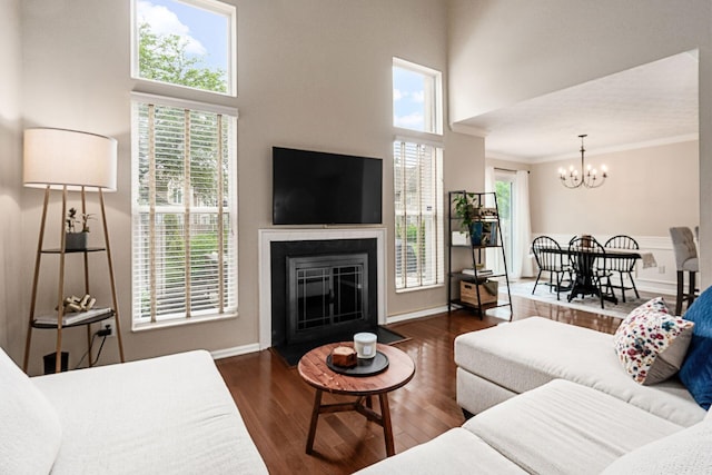 3381 Fishinger Mill Dr, Hilliard, OH 43026 - living area with a chandelier, wood finished floors, a fireplace with flush hearth, ornamental molding, and a high ceiling