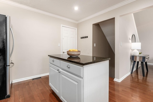 3381 Fishinger Mill Dr, Hilliard, OH 43026 - kitchen featuring freestanding refrigerator, dark wood finished floors, crown molding, white cabinetry, and a kitchen island