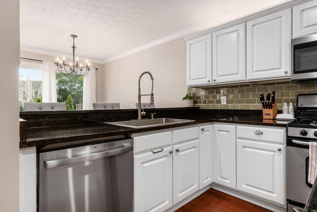 3381 Fishinger Mill Dr, Hilliard, OH 43026 - kitchen with appliances with stainless steel finishes, crown molding, a chandelier, a textured ceiling, and tasteful backsplash