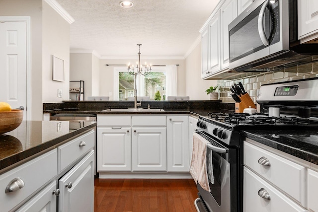 3381 Fishinger Mill Dr, Hilliard, OH 43026 - kitchen featuring appliances with stainless steel finishes, a textured ceiling, ornamental molding, a chandelier, and white cabinets