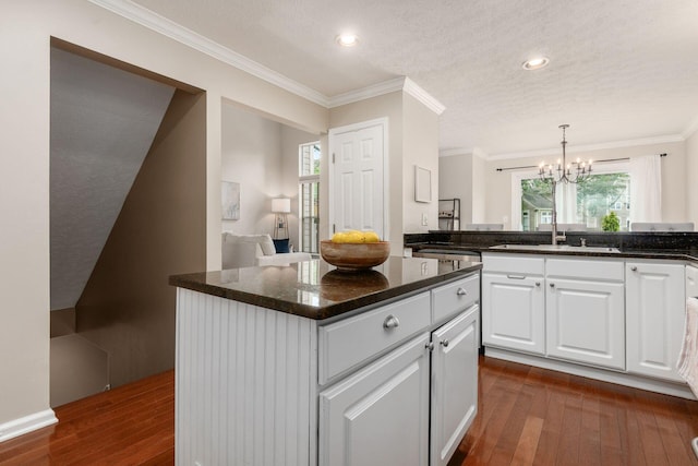 3381 Fishinger Mill Dr, Hilliard, OH 43026 - kitchen featuring dark wood-style floors, a chandelier, white cabinets, healthy amount of natural light, and crown molding