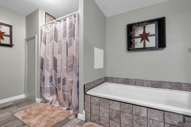 562 Bowman Ln, Chillicothe, OH 45601 - bathroom with a textured ceiling, a bath, wood finished floors, and curtained shower