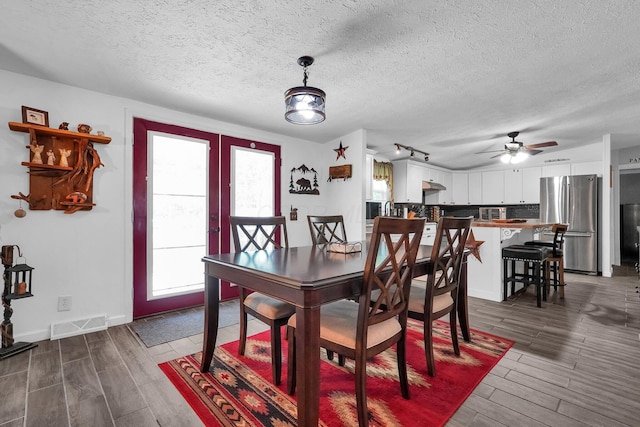 562 Bowman Ln, Chillicothe, OH 45601 - dining room featuring a textured ceiling, wood tiled floors, a ceiling fan, rail lighting, and french doors