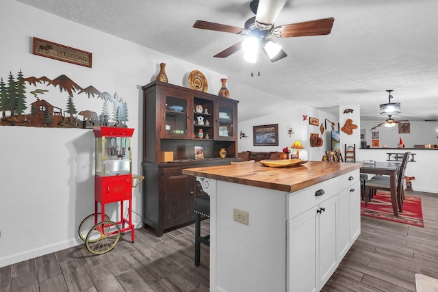 562 Bowman Ln, Chillicothe, OH 45601 - kitchen featuring a ceiling fan, butcher block countertops, wood finished floors, white cabinetry, and a textured ceiling