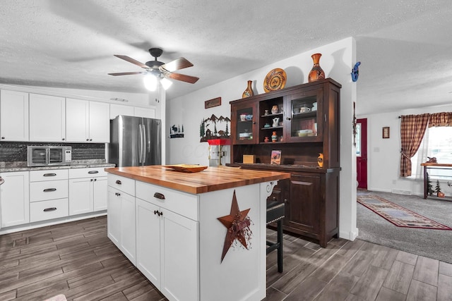 562 Bowman Ln, Chillicothe, OH 45601 - kitchen featuring butcher block counters, freestanding refrigerator, a textured ceiling, dark wood finished floors, and a ceiling fan