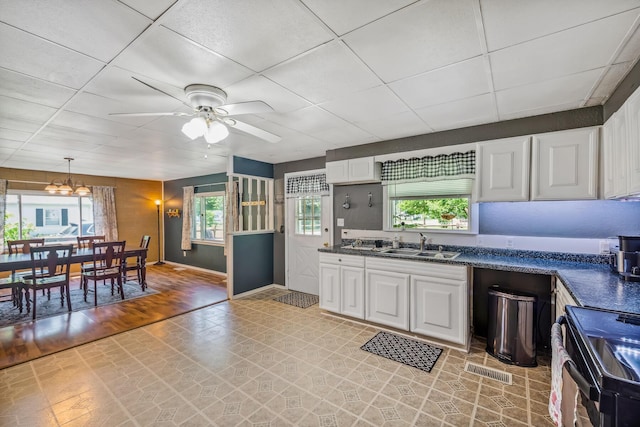 247 3rd St, La Rue, OH 43332 - kitchen featuring black electric range, white cabinets, plenty of natural light, a ceiling fan, and a drop ceiling