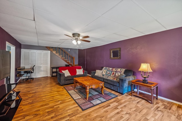 247 3rd St, La Rue, OH 43332 - living room featuring wood finished floors, a paneled ceiling, ceiling fan, and stairs