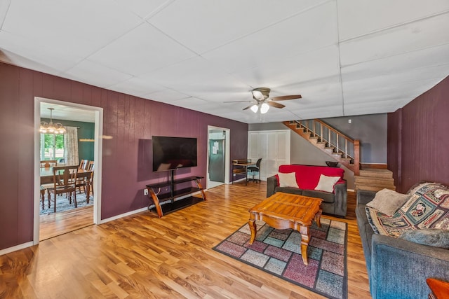 247 3rd St, La Rue, OH 43332 - living room featuring stairs, wood finished floors, a ceiling fan, a chandelier, and wooden walls