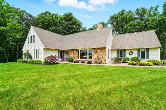 8384 Morris Rd, Hilliard, OH 43026 - cape cod house featuring a shingled roof, a chimney, a front yard, stone siding, and a patio
