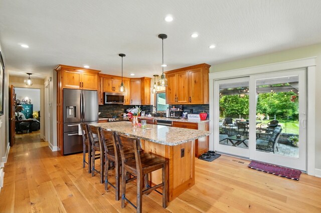 8384 Morris Rd, Hilliard, OH 43026 - kitchen with appliances with stainless steel finishes, light wood-style floors, decorative backsplash, light stone countertops, and recessed lighting