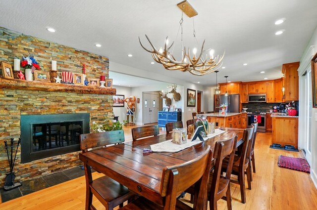 8384 Morris Rd, Hilliard, OH 43026 - dining room featuring recessed lighting, a chandelier, light wood-type flooring, and a stone fireplace
