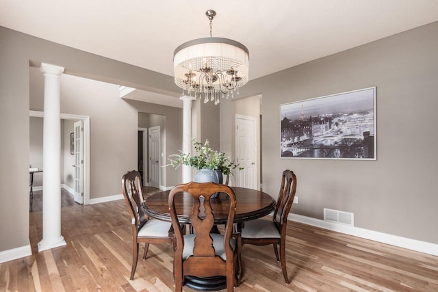 2467 Roe Dr, Lewis Center, OH 43035 - dining room featuring light wood-style flooring, a chandelier, and ornate columns
