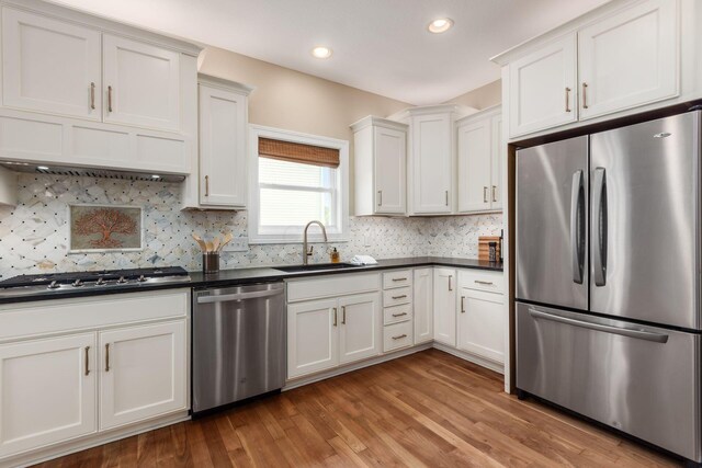 2467 Roe Dr, Lewis Center, OH 43035 - kitchen featuring appliances with stainless steel finishes, dark countertops, white cabinetry, light wood-style flooring, and recessed lighting
