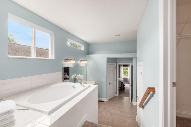 2467 Roe Dr, Lewis Center, OH 43035 - ensuite bathroom featuring a bath, healthy amount of natural light, a spacious closet, and tile patterned floors