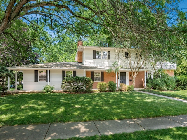 6509 Evening St, Worthington, OH 43085 - traditional-style house featuring a front lawn, a chimney, and brick siding