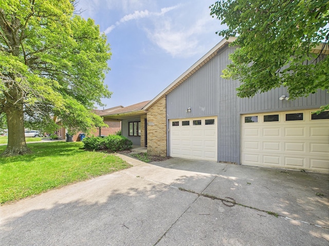 6343 Birchview Dr S Unit 6343-6345, Reynoldsburg, OH 43068 - view of front of home featuring concrete driveway, a front yard, brick siding, and a garage