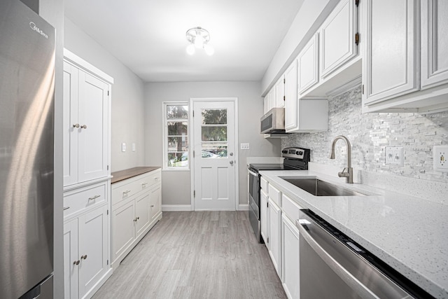 1608 Arlington Ave, Marble Cliff, OH 43212 - kitchen featuring appliances with stainless steel finishes, white cabinetry, light wood-style floors, tasteful backsplash, and light stone countertops