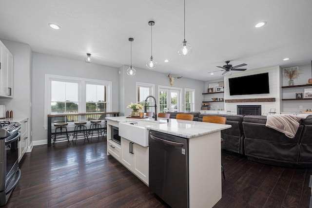 1526 Crosley Rd, Granville, OH 43023 - kitchen with appliances with stainless steel finishes, ceiling fan, dark wood-type flooring, light stone counters, and a fireplace