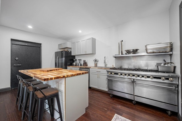 1526 Crosley Rd, Granville, OH 43023 - kitchen with butcher block countertops, appliances with stainless steel finishes, a kitchen breakfast bar, dark wood-style floors, and recessed lighting