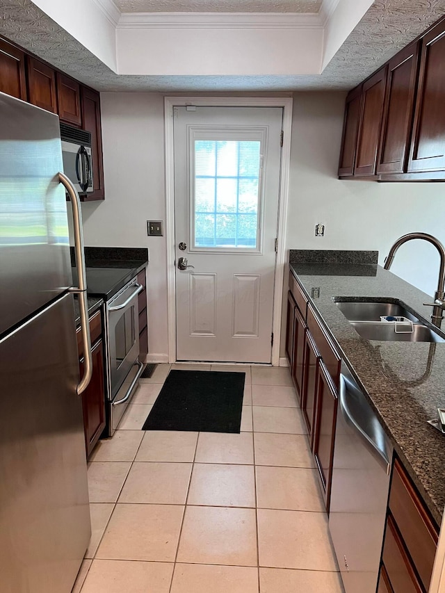 347 W 5th Ave, Columbus, OH 43201 - kitchen featuring stainless steel appliances, a tray ceiling, dark stone counters, light tile patterned flooring, and crown molding