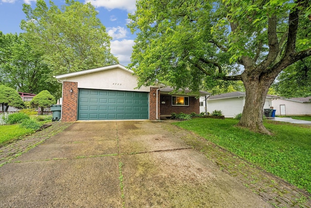 4750 Manitoba Ct, Columbus, OH 43229 - view of front of property featuring a garage, brick siding, a front yard, and concrete driveway