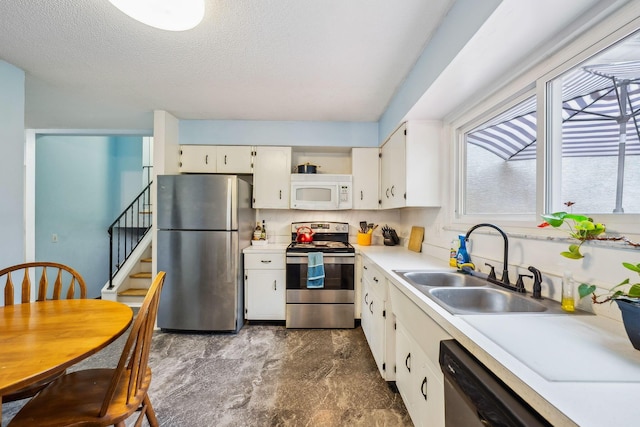 4750 Manitoba Ct, Columbus, OH 43229 - kitchen featuring stainless steel appliances, light countertops, white cabinets, and a textured ceiling