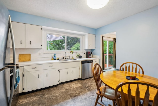 4750 Manitoba Ct, Columbus, OH 43229 - kitchen with stainless steel appliances, a textured ceiling, white cabinets, and light countertops