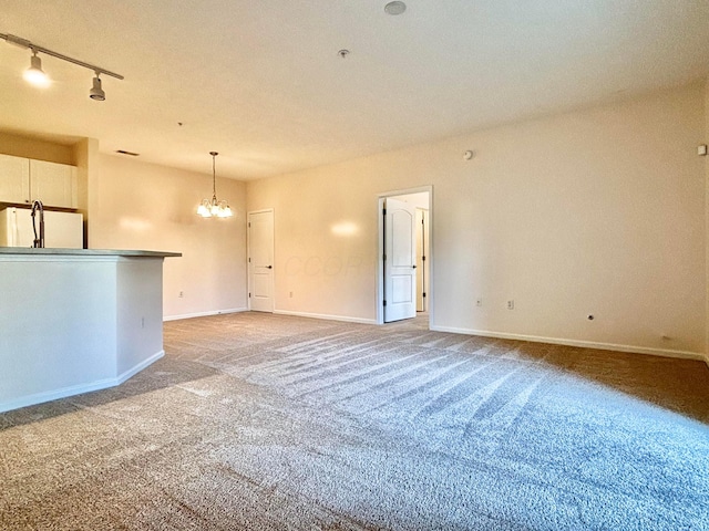 3839 Carberry Dr, Dublin, OH 43016 - unfurnished living room featuring light colored carpet, a chandelier, and track lighting