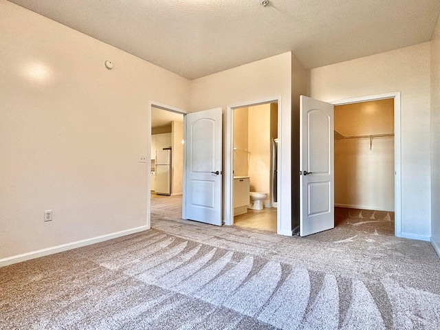 3839 Carberry Dr, Dublin, OH 43016 - unfurnished bedroom featuring freestanding refrigerator, carpet flooring, a walk in closet, and connected bathroom