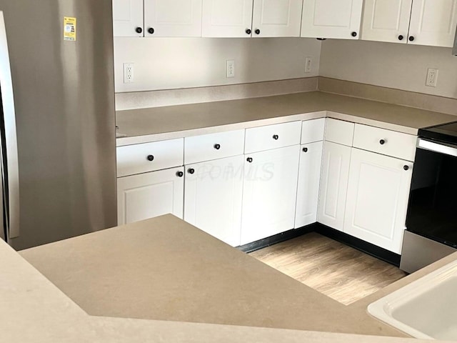8061 Cranes Crossing Dr, Lewis Center, OH 43035 - kitchen featuring appliances with stainless steel finishes, white cabinets, wood finished floors, and light countertops