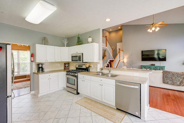 7029 Post Preserve Blvd, Dublin, OH 43016 - kitchen featuring appliances with stainless steel finishes, open floor plan, white cabinetry, ceiling fan, and a peninsula
