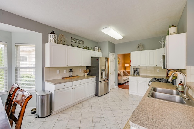 7029 Post Preserve Blvd, Dublin, OH 43016 - kitchen with stainless steel appliances, white cabinets, light marble finish flooring, tasteful backsplash, and light countertops