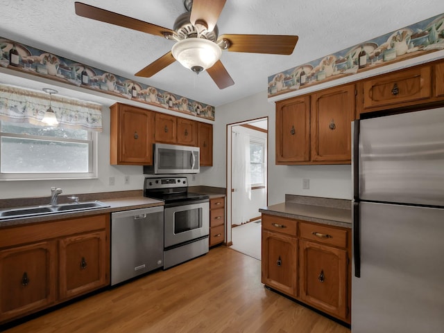 1380 Hanbury Ct, Gahanna, OH 43230 - kitchen featuring appliances with stainless steel finishes, brown cabinets, dark countertops, and a textured ceiling