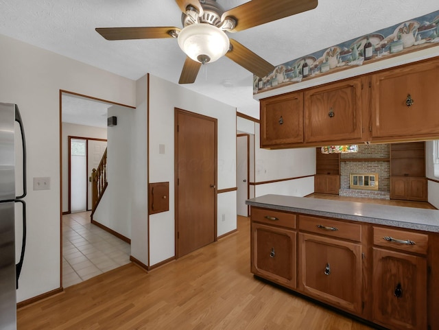 1380 Hanbury Ct, Gahanna, OH 43230 - kitchen featuring freestanding refrigerator, brown cabinetry, a ceiling fan, and light wood finished floors