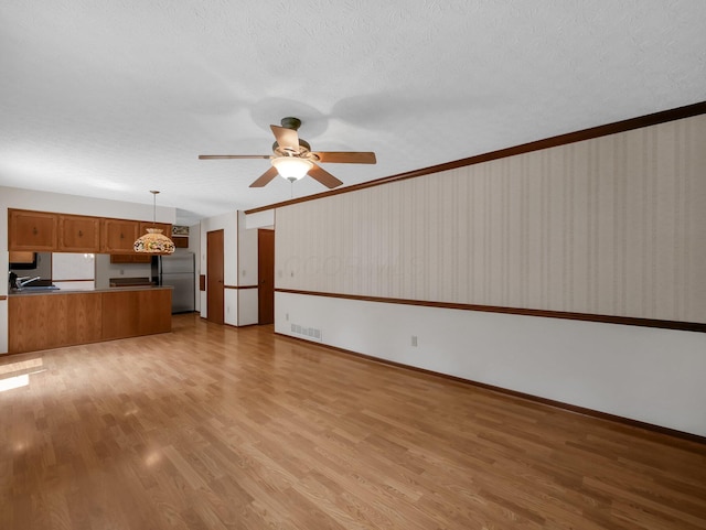 1380 Hanbury Ct, Gahanna, OH 43230 - unfurnished living room with a ceiling fan, light wood-style floors, and a textured ceiling