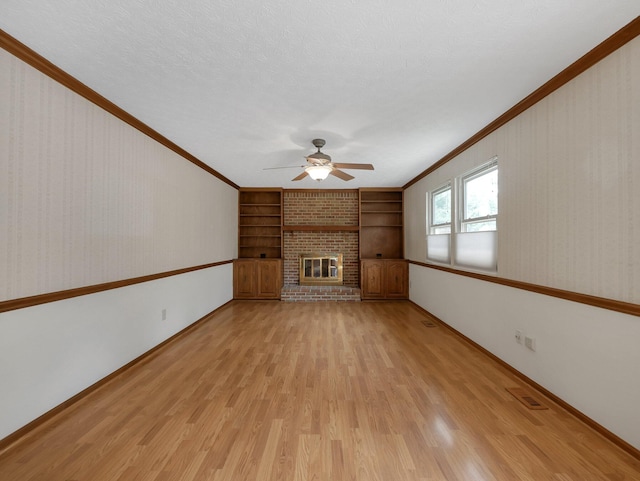 1380 Hanbury Ct, Gahanna, OH 43230 - unfurnished living room featuring a ceiling fan, light wood-type flooring, a brick fireplace, built in features, and crown molding