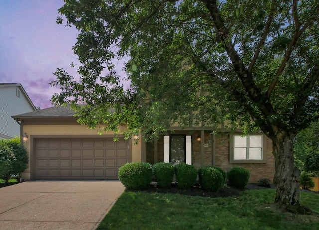 1380 Hanbury Ct, Gahanna, OH 43230 - view of property hidden behind natural elements featuring an attached garage, concrete driveway, brick siding, and stucco siding