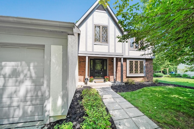 6978 Ernest Way, Dublin, OH 43017 - tudor-style house featuring stucco siding, a front lawn, brick siding, and an attached garage