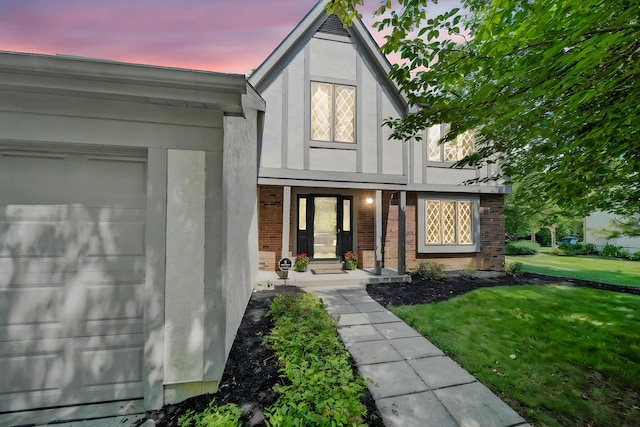 6978 Ernest Way, Dublin, OH 43017 - view of front facade with stucco siding, brick siding, a lawn, and a garage