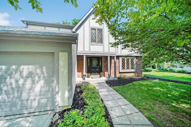 6978 Ernest Way, Dublin, OH 43017 - tudor house featuring a garage, a front yard, stucco siding, and brick siding