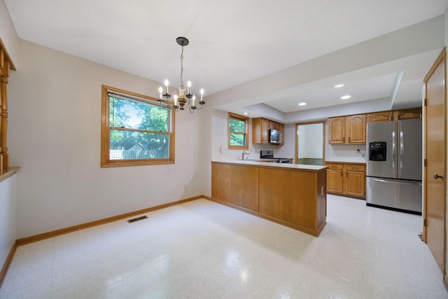 6978 Ernest Way, Dublin, OH 43017 - kitchen with stainless steel appliances, brown cabinets, a chandelier, light flooring, and a peninsula