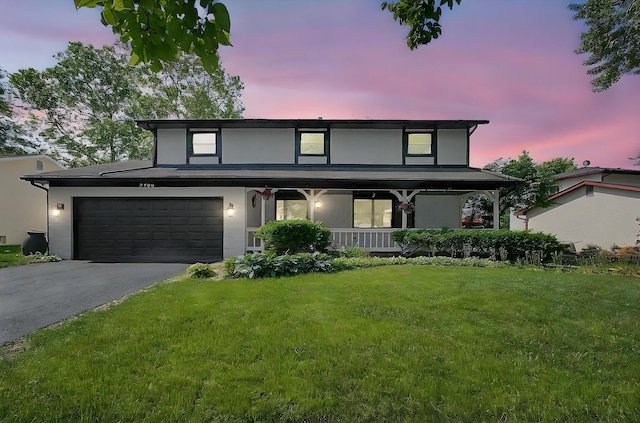 2709 Patrick Ave, Columbus, OH 43231 - view of front of house with covered porch, driveway, a front lawn, and stucco siding