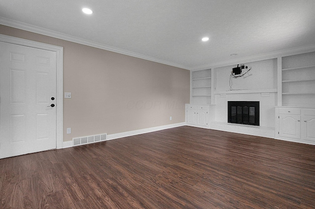 2709 Patrick Ave, Columbus, OH 43231 - unfurnished living room with dark wood-style flooring, built in shelves, crown molding, a brick fireplace, and recessed lighting