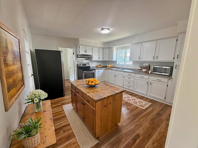 85 Blymer St, Delaware, OH 43015 - kitchen featuring appliances with stainless steel finishes, under cabinet range hood, wood finished floors, white cabinets, and a kitchen island