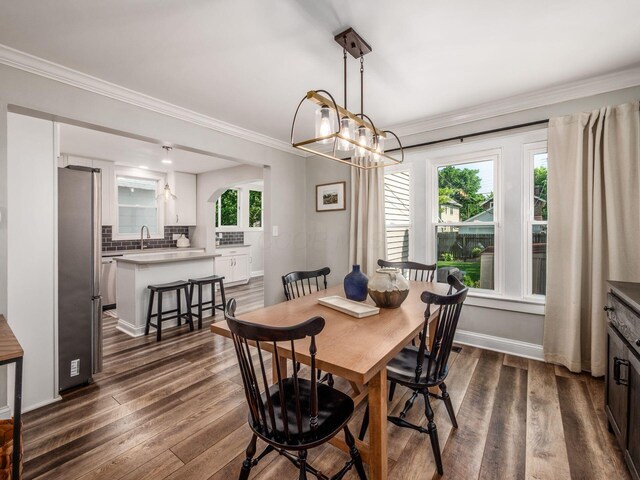 185 Frebis Ave, Columbus, OH 43206 - dining room featuring dark wood-type flooring, ornamental molding, and a chandelier