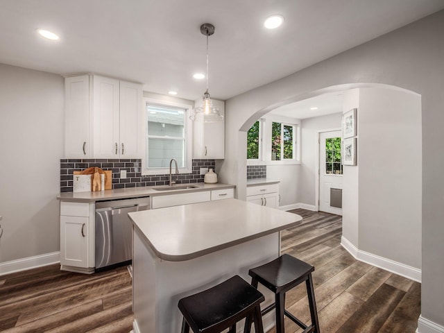 185 Frebis Ave, Columbus, OH 43206 - kitchen with dishwasher, arched walkways, dark wood-type flooring, tasteful backsplash, and white cabinetry