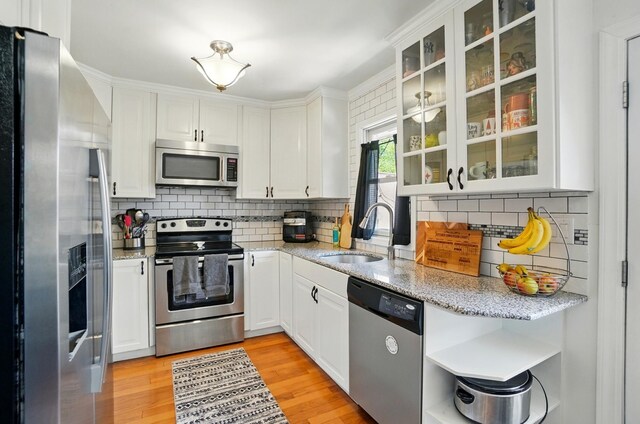 602 Dlyn St Unit H8, Columbus, OH 43228 - kitchen with appliances with stainless steel finishes, open shelves, white cabinetry, decorative backsplash, and glass insert cabinets