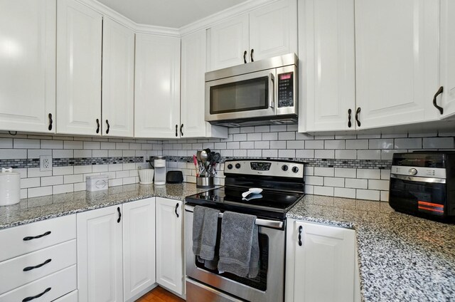 602 Dlyn St Unit H8, Columbus, OH 43228 - kitchen featuring appliances with stainless steel finishes, white cabinets, and tasteful backsplash